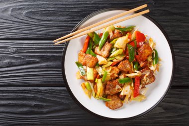  İki kez pişirilmiş domuz eti, lezzetli bir sosta pişirilmiş yağlı domuz eti ve ahşap masadaki tabakta yakın plan sebzeler. Yukarıdan yatay üst görünüm