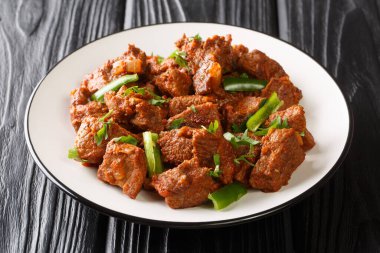 Tibs African dish made from roasted beef in a spicy vegetable sauce with Berbere spices close-up in a plate on the table. horizonta