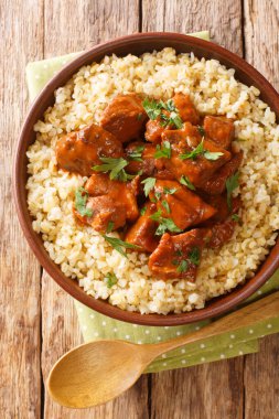 Afelia, kırmızı şarap ve kişniş eşliğinde pişirilen ve bulgur pilavı ile birlikte tabakta yakın plan yapılan geleneksel bir Kıbrıs domuz eti türüdür. Yukarıdan dikey üst görünüm