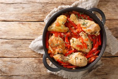 Peppers Poulet Basquaise ile Bask usulü haşlanmış tavuk masanın üzerindeki tavaya yakın. Yukarıdan yatay üst görünüm
