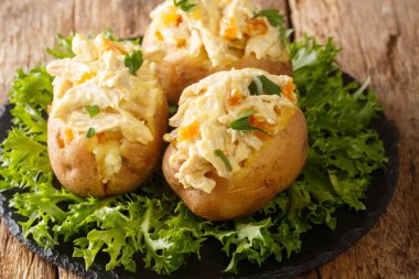 Taç giyme töreni tavuğu salatasıyla doldurulmuş ev yapımı sıcak patatesler masanın üzerindeki tabakta. Yatay