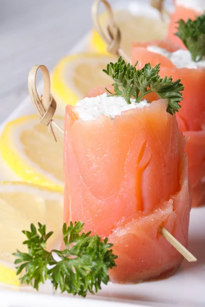 Rouleaux de saumon et fromage à la crème sur une plaque blanche macro — Photo