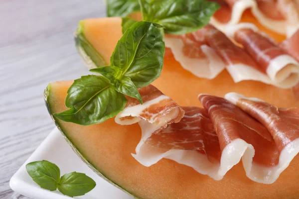 Pieces of melon with ham and basil macro horizontal — Stock Photo, Image