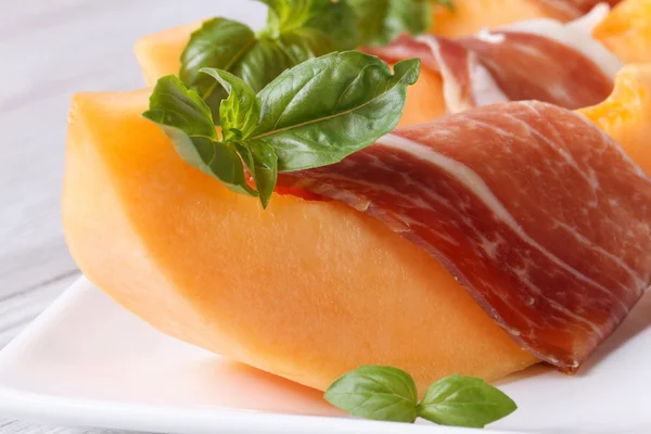 Sliced melon wrapped in prosciutto horizontal macro — Stock Photo, Image