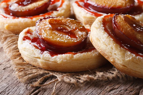 Pies of flaky pastry with plums close up horizontal — Stock Photo, Image