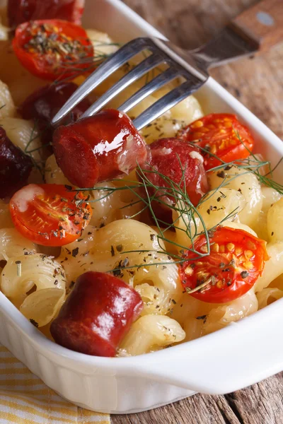 Pasta baked with cherry tomatoes and sausage and fork close-up — Stock Photo, Image