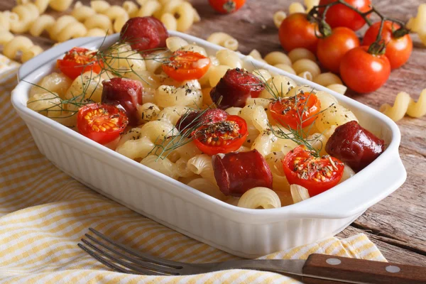 Pasta with tomatoes and sausages baked and ingredients — Stock Photo, Image