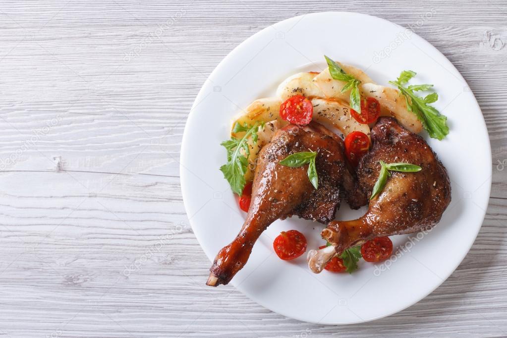 duck legs baked with apples and tomatoes  close-up top view