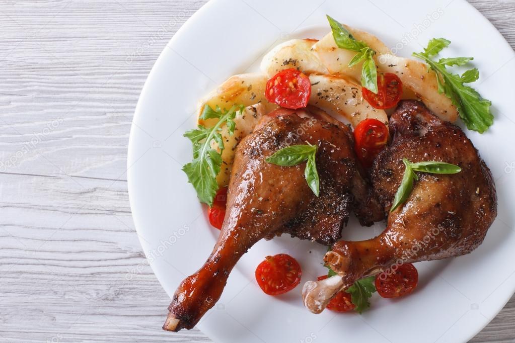 duck legs roasted with apples and tomatoes  close-up top view
