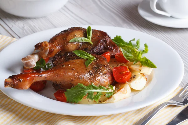Lezzetli yemek: kızarmış ördek bacaklar, elma, domates ve otlar ile — Stok fotoğraf