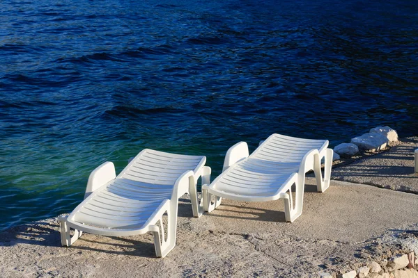 Deux chaises longues en plastique près de la mer — Photo