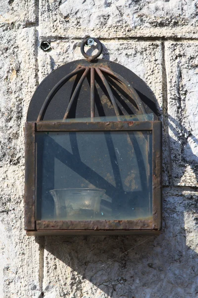 Velha lanterna de ferro com uma vela na parede — Fotografia de Stock