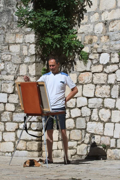 Street artist avec un chevalet et un chat . — Photo