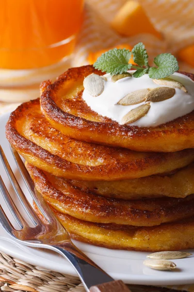 Pumpkin pancakes with sour cream close-up on the table. — Stock Photo, Image