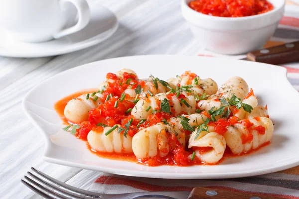 Картопляні гноки з томатним соусом на білій тарілці — стокове фото