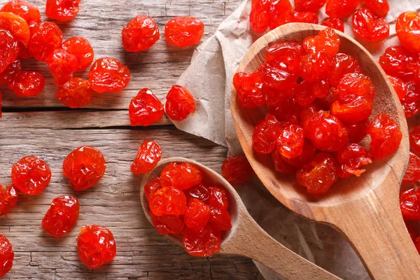 Dried red cherries in a wooden spoon macro. top view — Stock Photo, Image