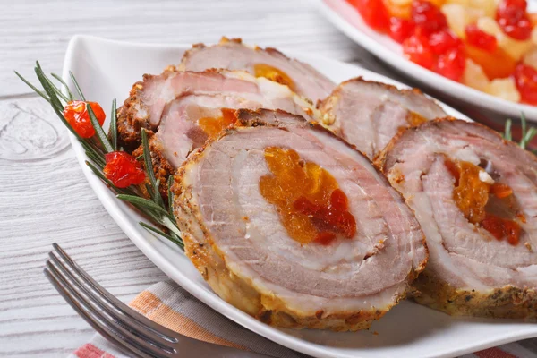 Rotolo di maiale con albicocca e ciliegia primo piano su un piatto bianco — Foto Stock