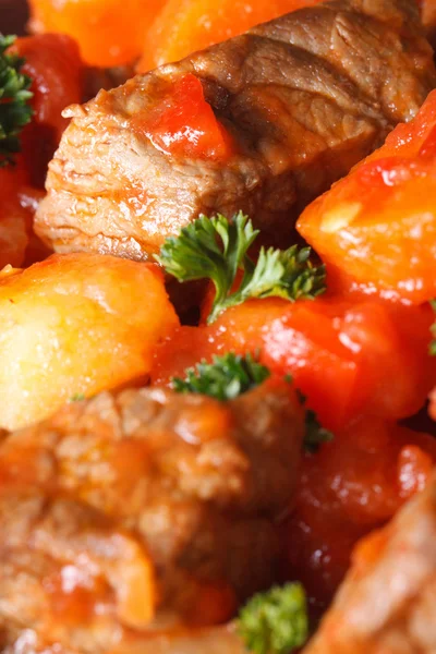 Guisado de carne de vaca com verduras em uma macro de tomate. Vertical — Fotografia de Stock