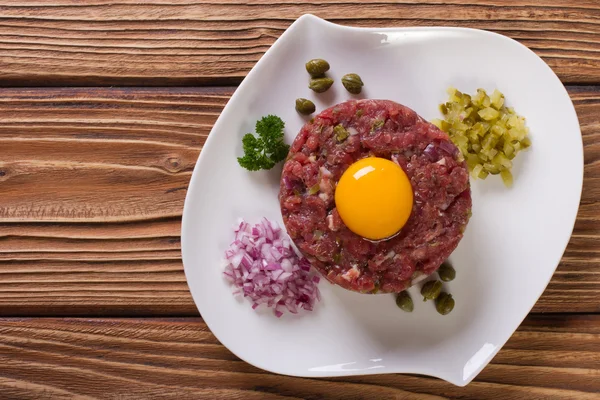 Tartare with egg, capers and cucumbers close-up top view — Stock Photo, Image