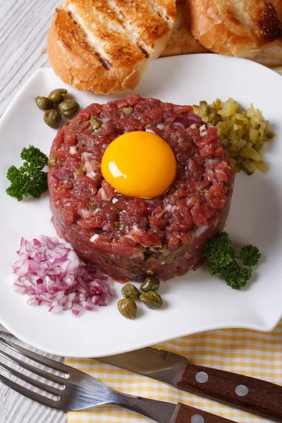 Beef tartare close up on a white plate. vertical top view — Stock Photo, Image