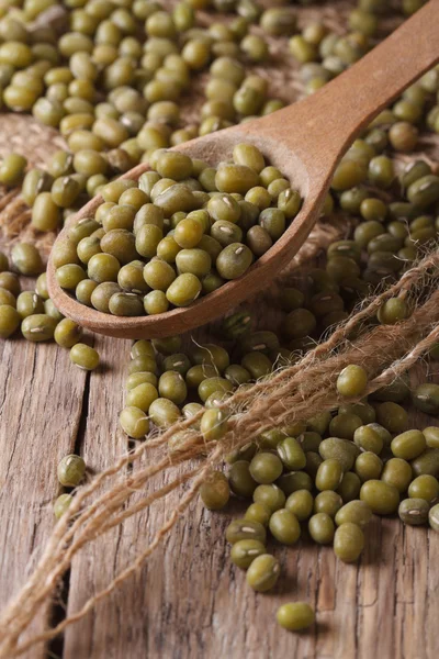 Green mung bean in wooden spoon closeup on the table. vertical — Stock Photo, Image