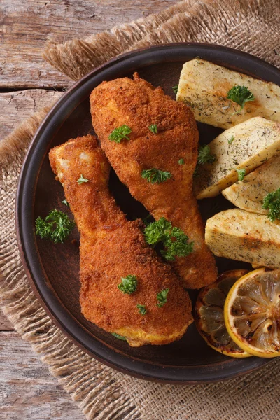 Chicken legs in batter, with potato on the plate. top view verti — Stock Photo, Image