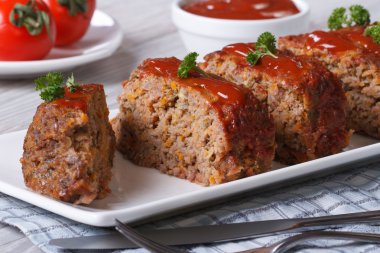 Sliced meat loaf with ketchup and parsley close-up clipart