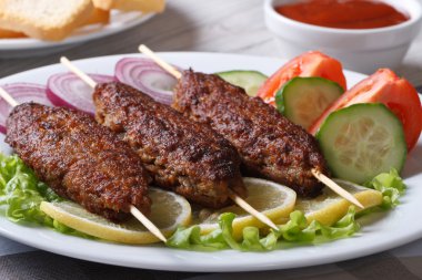 ahşap şişleri ve taze sebze bir tabakta kebap 