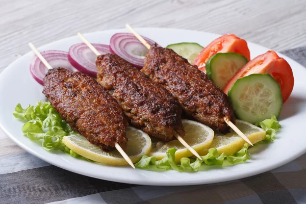 Kebabs grelhados em espetos de madeira e legumes frescos — Fotografia de Stock