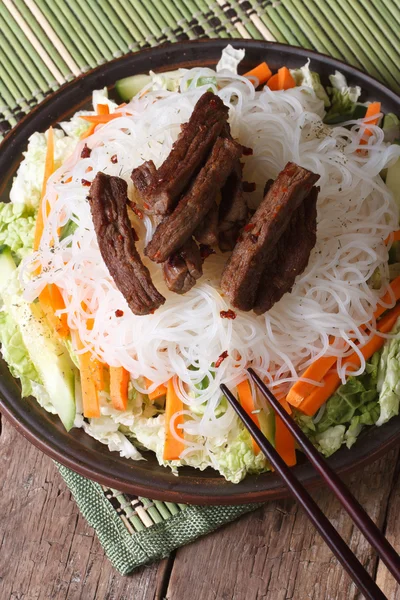 Asian rice noodles with meat and vegetables vertical