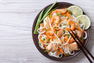 rice noodles with chicken, shrimp and vegetables top view clipart