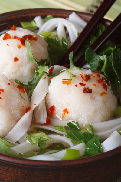 Soup with fish balls, noodles and fresh herbs macro. Vertical — Stock Photo, Image