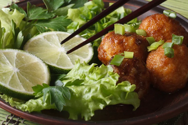 Vis ballen met kalk en salade en eetstokjes macro. Horizontale — Stockfoto