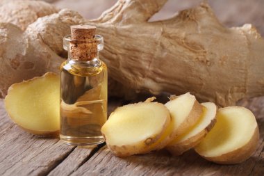 oil of ginger in a small glass bottle macro and root  clipart