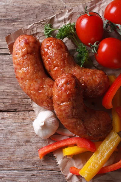 Grilled sausages with vegetables close up vertical top view — Stock Photo, Image