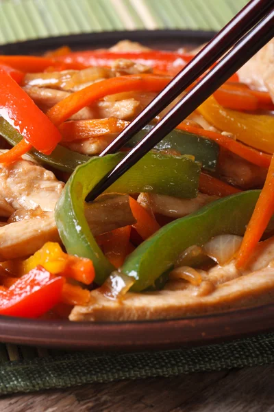 Chicken with peppers, carrots macro and chopsticks, vertical — Stock Photo, Image