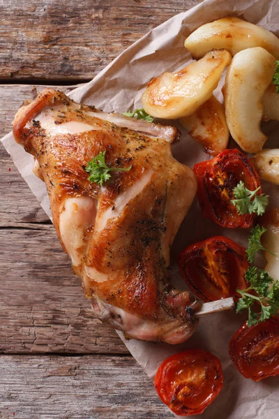 Jambe de lapin rôtie avec pommes et tomates vue de dessus verticale — Photo