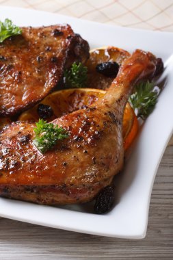 Kızarmış ördek bacak dikey bir beyaz tabakta portakal ile