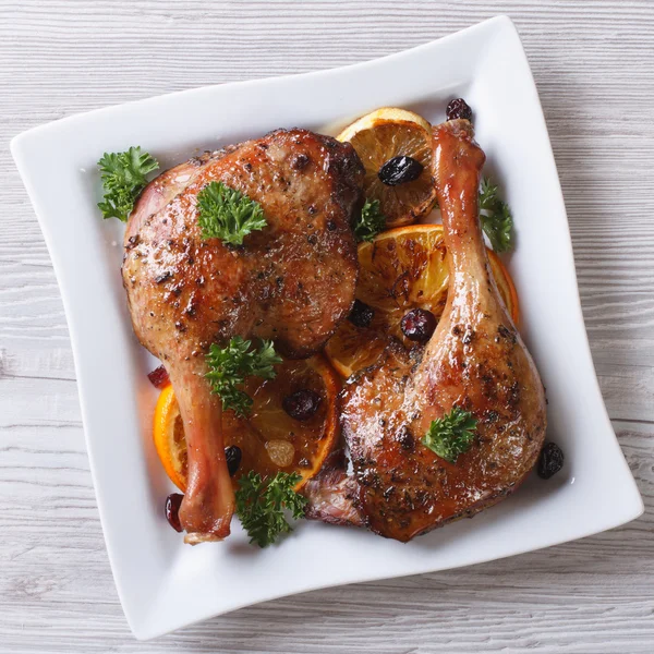 Roasted duck leg with oranges on a white plate closeup. top view — Stock Photo, Image