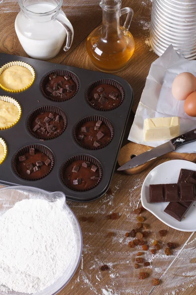 Cooking chocolate and vanilla cupcakes close-up vertical — Stock Photo, Image