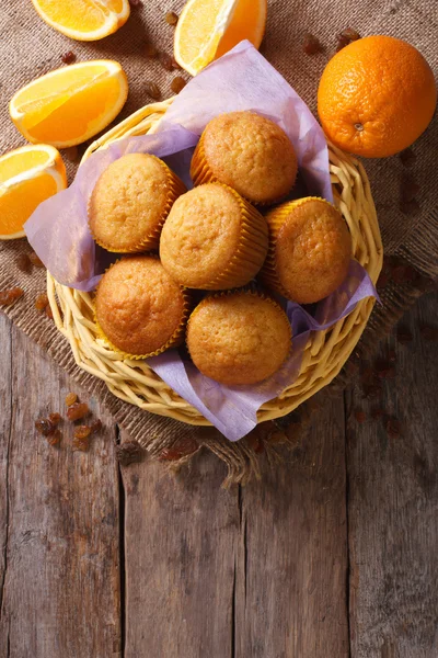 Εσπεριδοειδών muffins και φρέσκα πορτοκάλια close-up. Κάθετη κάτοψη — Φωτογραφία Αρχείου