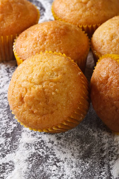 Muffins orange makro på mjölat bord. vertikala ovanifrån — Stockfoto