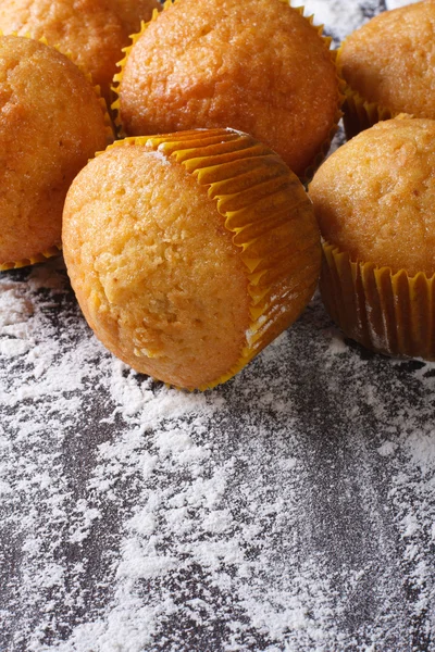 Vers gebakken oranje muffins en meel, bovenaanzicht verti morsen — Stockfoto