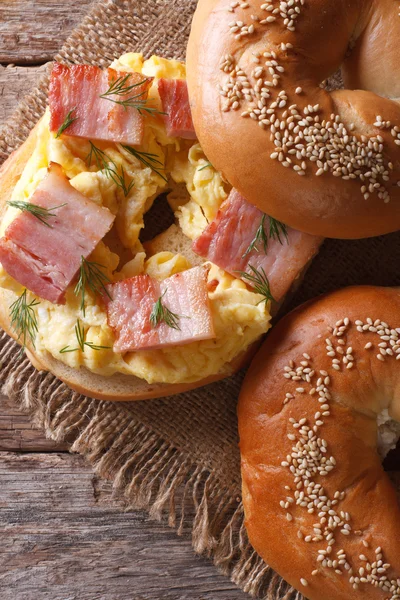 Bagel med ägg och bacon närbild. Vertikala vy från ovan — Stockfoto