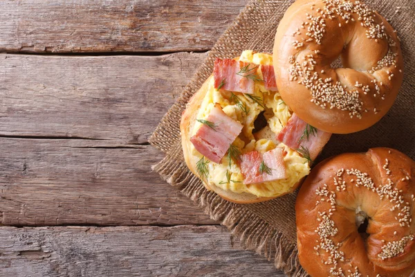 Bagel med ägg och bacon närbild. horisontell vy från ovan — Stockfoto