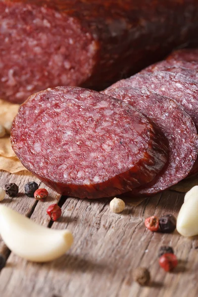 Sliced smoked sausage with spices vertical macro — Stock Photo, Image