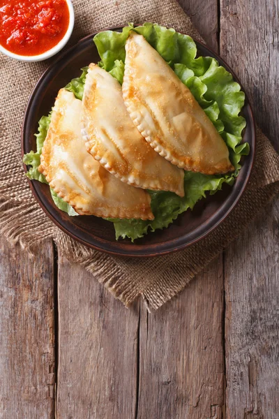 Empanadas and sauce closeup. vertical top view, rustic — Stock Photo, Image