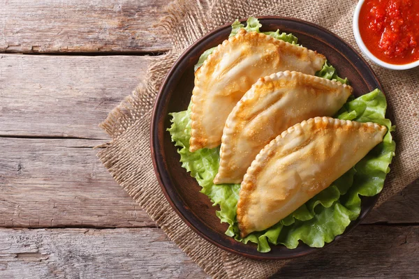 Traditional empanadas and sauce closeup. horizontal top view — Stock Photo, Image