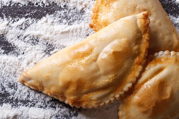 Empanadas sobre una mesa con derrames de harina. vista superior horizontal —  Fotos de Stock