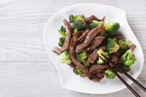 Carne asiática com brócolis e pauzinhos. vista horizontal superior — Fotografia de Stock